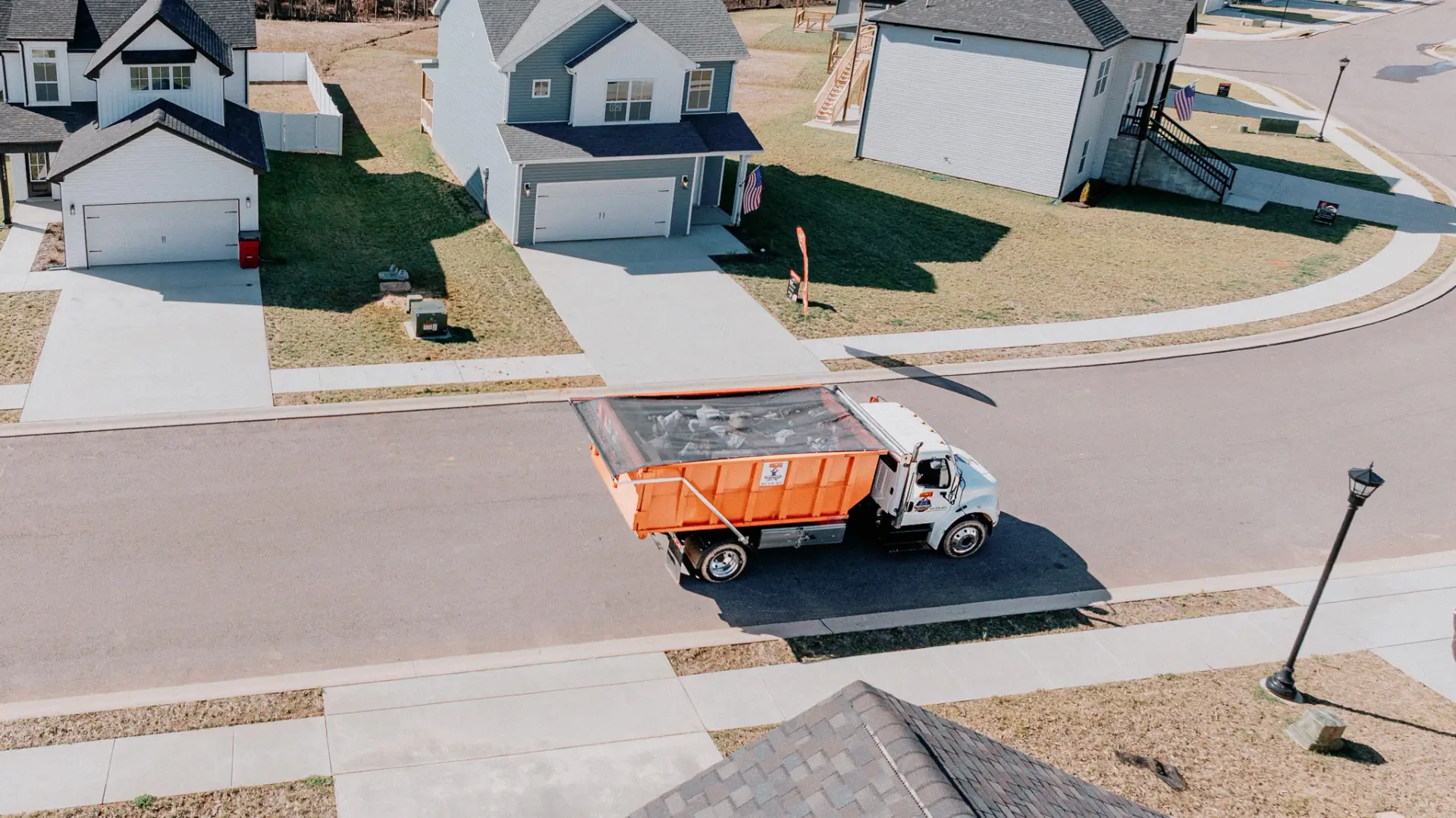 Underdog Dumpster truck delivering a residential roll-off dumpster in a Clarksville neighborhood